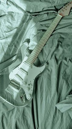 an electric guitar laying on top of a bed