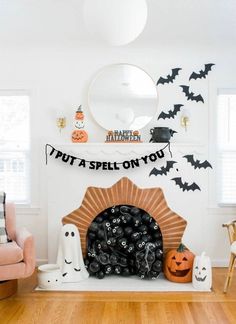 a living room decorated for halloween with pumpkins and bats on the fireplace mantel