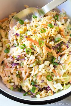 a white bowl filled with coleslaw salad and a silver spoon in the bowl