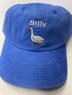 Looking for a fun and quirky accessory to add to your everyday look? Look no further than the None Silly Goose Dad Hat! Crafted from high-quality materials by trusted maker Port Authority, this washed blue hat is the perfect way to add a touch of humor to your outfit. The hat's playful design features a silly goose graphic front and center, adding an element of lighthearted fun that's sure to turn heads. With its comfortable fit and adjustable strap, this Dad Hat is perfect for any casual occasi Cheap Fun Blue Hats, Summer Washed Hats, One Size Fits Most, Summer Washed Hat, One Size Fits Most, Summer Washed Hats One Size Fits Most, Summer Adjustable Soft-washed Baseball Cap, Summer Soft-washed Adjustable Baseball Cap, Blue Washed Summer Hat, Trendy Adjustable Soft-washed Hat, Cute Cotton Baseball Cap With Curved Brim