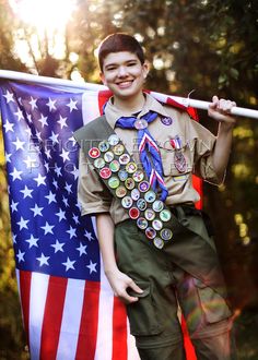 a young boy is holding an american flag and posing for a photo on instagram