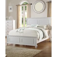 a white bed sitting on top of a wooden floor next to a dresser and mirror