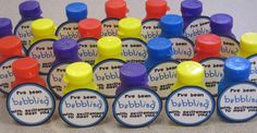 many different colored bottle caps with the words envidida written on them in blue, yellow, and red