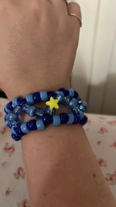 a person wearing two bracelets with blue beads and a yellow star on the end