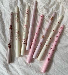 four pink and white pens are lined up on a sheet