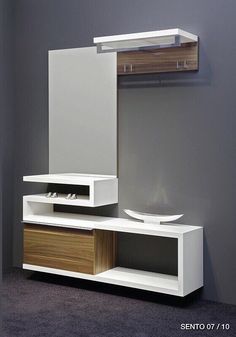 a white and brown entertainment center sitting on top of a carpeted floor next to a gray wall