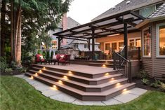 an outdoor patio with stairs and lights on the steps leading up to a covered deck