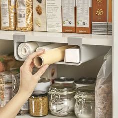 a person is opening the door to a pantry filled with spices and cereals on shelves