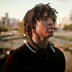 a young man with dreadlocks looking off into the distance