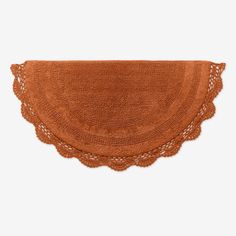 an orange place mat with crocheted edges