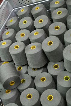 many gray spools of yarn sitting in a basket