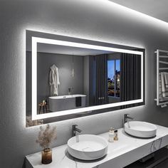 a bathroom with two sinks and a large mirror over it's sink, in front of a cityscape