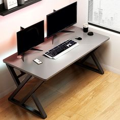 a computer desk with two monitors and a keyboard