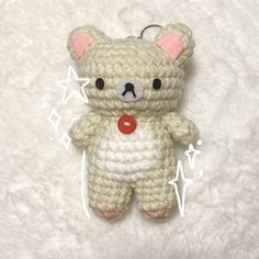 a crocheted teddy bear keychain is shown on a white background with stars