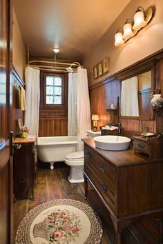 a bathroom with a sink, toilet and bathtub in the middle of wood paneled walls