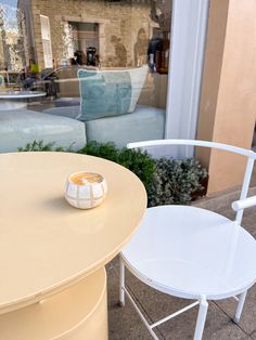 two white chairs sitting next to each other near a table