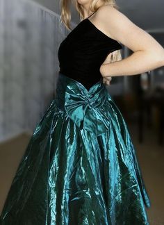 Fun 1980’s prom dress. Black velvet bodice and a green metallic skirt and large bow. One spaghetti shoulder strap. There is a rip in the metallic skirt, see photoBust: 28” (yes, 28” bust)Waist: 24”Hips: freeModel is 5’6” 80 Prom Dresses 1980s, 80’s Prom Dress, 80s Prom Aesthetic, 80s Prom Dress Costume, 90's Prom, 80s Fashion Dresses, Dresses 1980s, 1980s Prom Dress, 1980s Prom