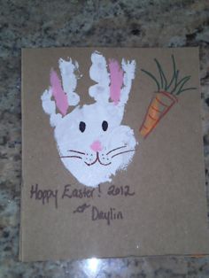 a bunny handprinted on a brown card with the words happy easter and a carrot