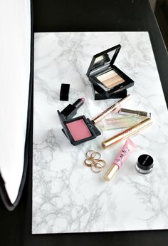 various makeup products are sitting on a marble table