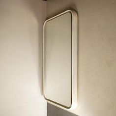 a bathroom mirror mounted on the wall above a sink