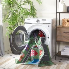 a washer and dryer are sitting next to each other in a room with towels on the floor