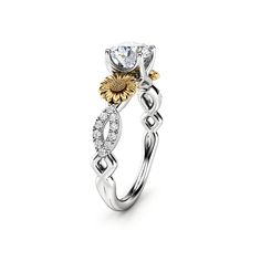 a white and yellow gold ring with flowers on it