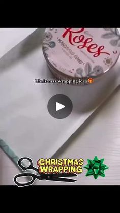 a roll of christmas wrapping tape sitting on top of a white table next to scissors