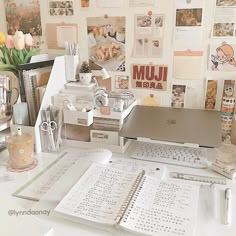 a white desk topped with lots of papers and laptop computer