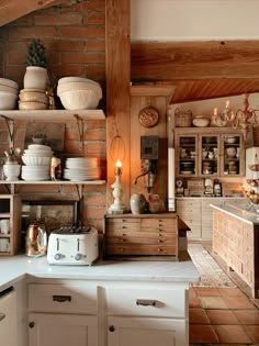 a kitchen filled with lots of white dishes and wooden shelves next to a stove top oven