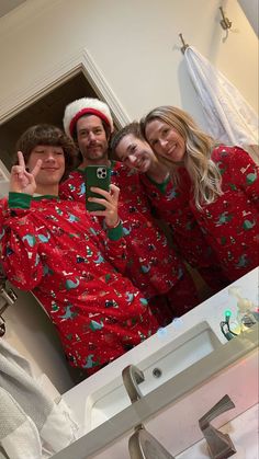 a group of people in christmas pajamas taking a selfie