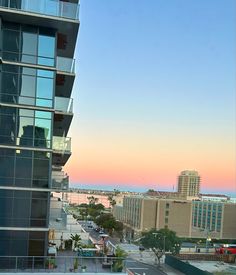 an apartment building with balconies overlooking the beach and ocean at sunset or dawn