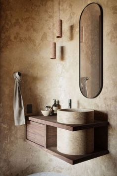 a bathroom sink sitting under a mirror next to a wall mounted faucet in front of a round mirror