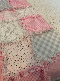 a close up of a quilt on a bed with pink and gray fabric, polka dots and ruffles