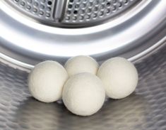 three balls of wool sitting on top of a washing machine