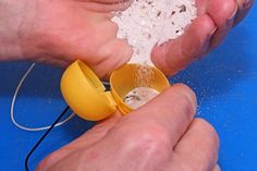 two hands are holding yellow measuring cups with white sugar in them and one hand is sprinkling something