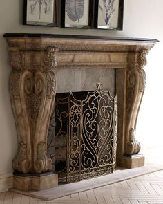 an ornate fireplace with two framed pictures above it