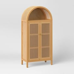 a wooden cabinet with an arched door and wicker design on the front, against a white background