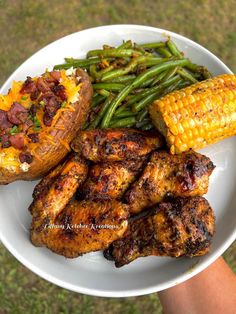 a white plate topped with chicken, green beans and corn