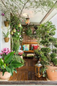 a wooden bench sitting in the middle of a garden filled with potted plants and flowers