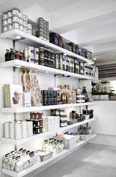 the shelves are filled with many different types of food and condiments in white