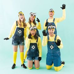 a group of people in minion costumes posing for a photo with their hands up