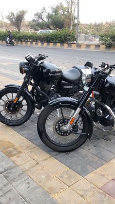 two motorcycles parked next to each other on the street