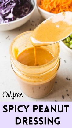 a spoon full of sauce being poured into a jar with the words oil free spicy peanut dressing