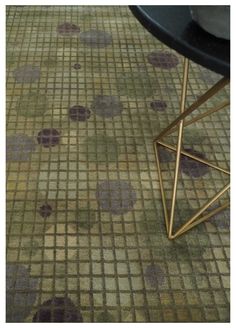 a table with a black top and some purple dots on the floor in front of it