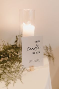 a candle that is sitting on top of a table next to a sign with the words candle burns