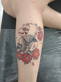 a woman's leg with a tattoo on it that has a cat sitting on top of flowers