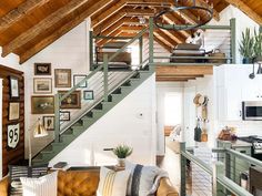 a living room filled with furniture next to a kitchen and loft style ceiling mounted on the wall