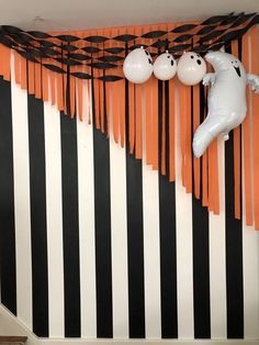 an orange and black striped room with ghost balloons