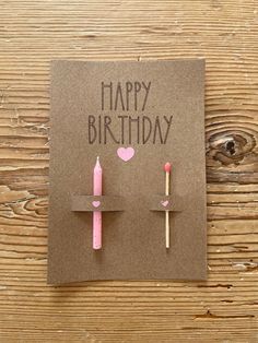 a birthday card with two candles on it and the words happy birthday written in pink