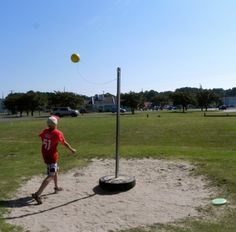 a young boy is throwing a frisbee in a field with a tee ball